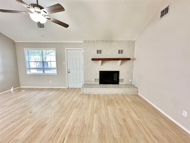 unfurnished living room with a brick fireplace, crown molding, light hardwood / wood-style flooring, and ceiling fan