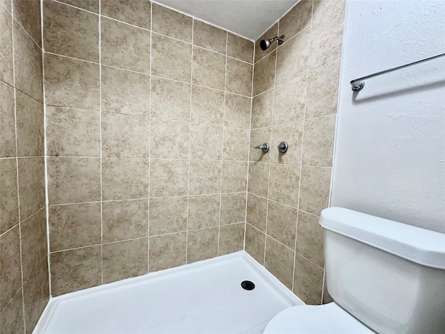 bathroom featuring toilet and tiled shower