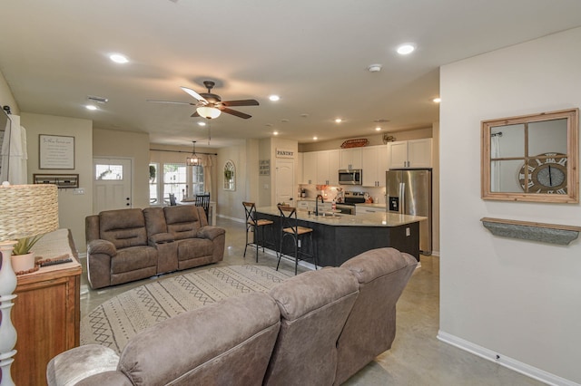 living room featuring ceiling fan and sink