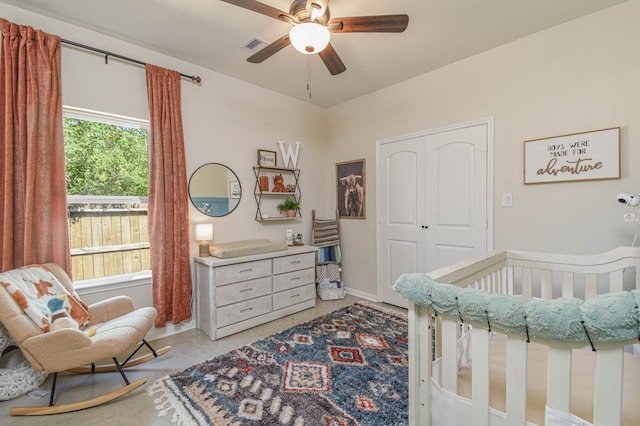 bedroom with a crib and ceiling fan