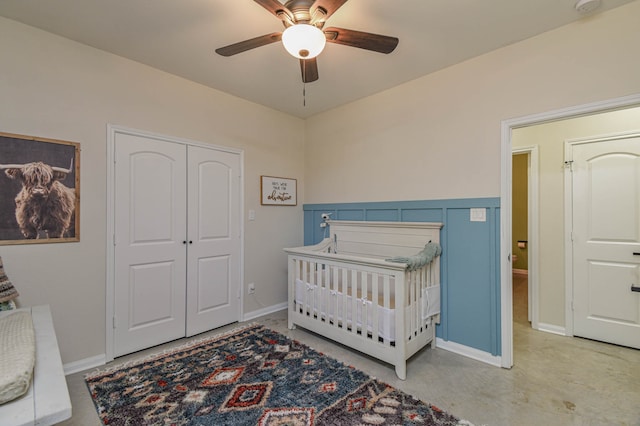 bedroom with a nursery area, a closet, and ceiling fan