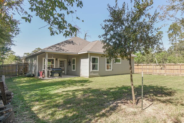 rear view of property with a yard and a patio area