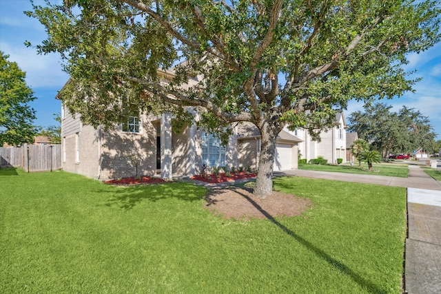 obstructed view of property with a front lawn and a garage