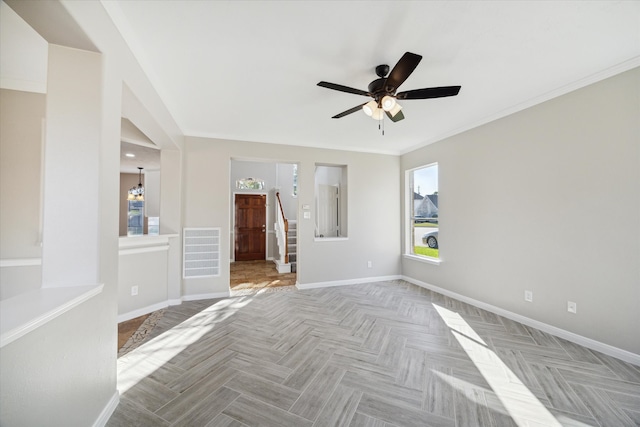 spare room with ceiling fan with notable chandelier, crown molding, plenty of natural light, and light parquet floors