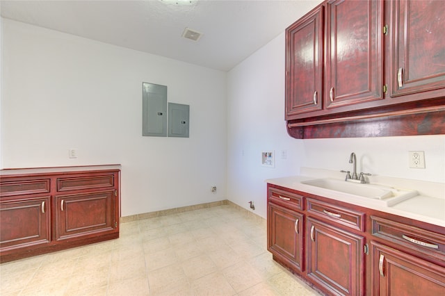 clothes washing area featuring electric panel, hookup for a washing machine, sink, and cabinets