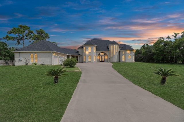 view of front of property with a garage and a yard