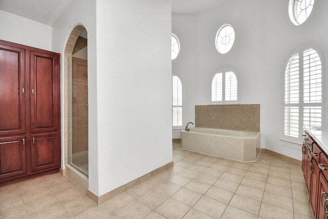 bathroom with tile patterned floors, a healthy amount of sunlight, vanity, and independent shower and bath