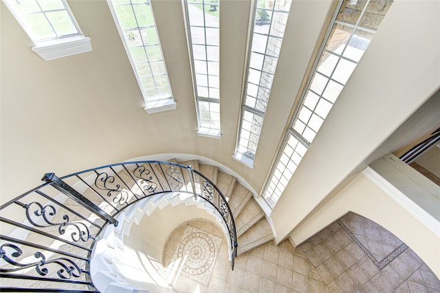 stairway featuring a high ceiling and a wealth of natural light