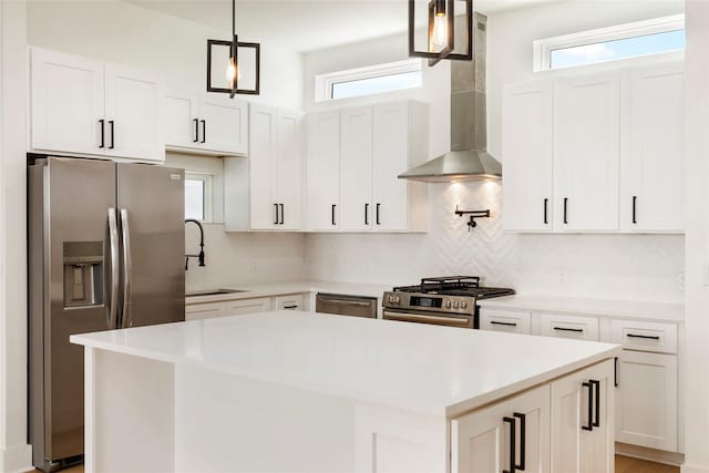 kitchen with pendant lighting, a healthy amount of sunlight, a kitchen island, and stainless steel appliances