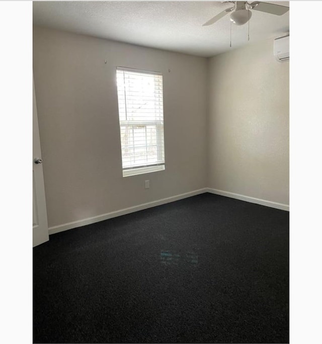 carpeted spare room featuring a textured ceiling, a wall mounted AC, and ceiling fan