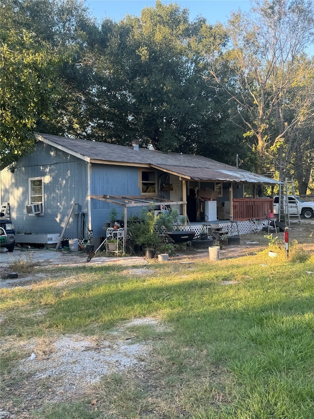 view of front facade featuring a deck, cooling unit, and a front lawn