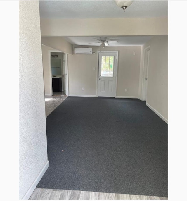 unfurnished room with a wall mounted air conditioner, carpet, and ceiling fan