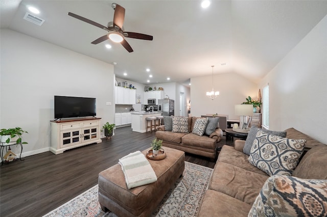 living room with ceiling fan with notable chandelier, lofted ceiling, and dark hardwood / wood-style floors