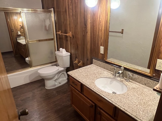 full bathroom featuring vanity, toilet, wood-type flooring, and enclosed tub / shower combo