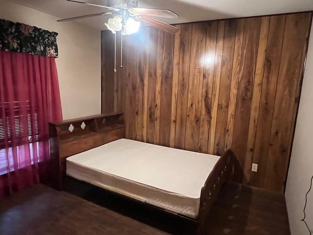 bedroom featuring wooden walls and ceiling fan