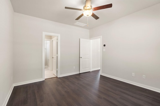 unfurnished bedroom featuring ceiling fan, ensuite bath, and dark wood-type flooring