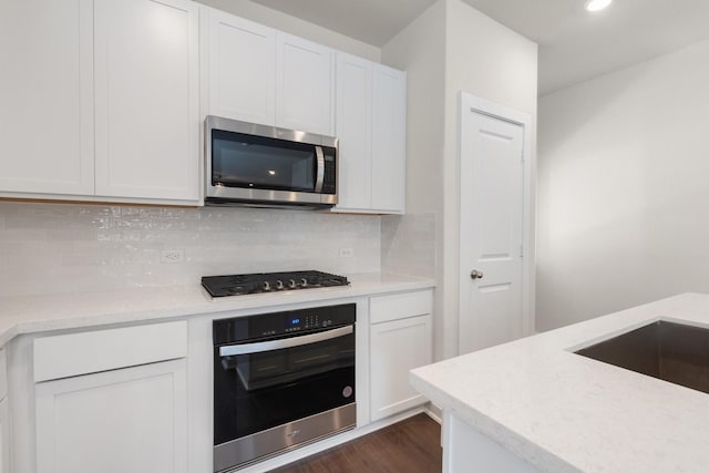 kitchen featuring wall oven, black gas cooktop, tasteful backsplash, white cabinets, and dark hardwood / wood-style floors