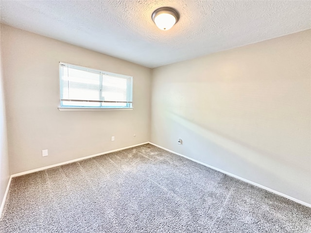 spare room with a textured ceiling and carpet