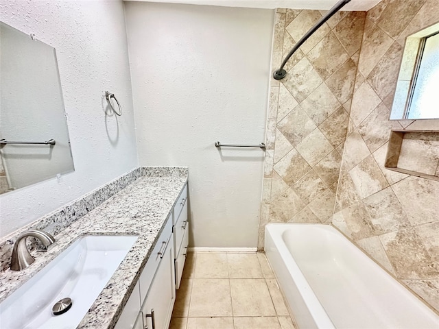 bathroom with tile patterned floors, vanity, and tiled shower / bath