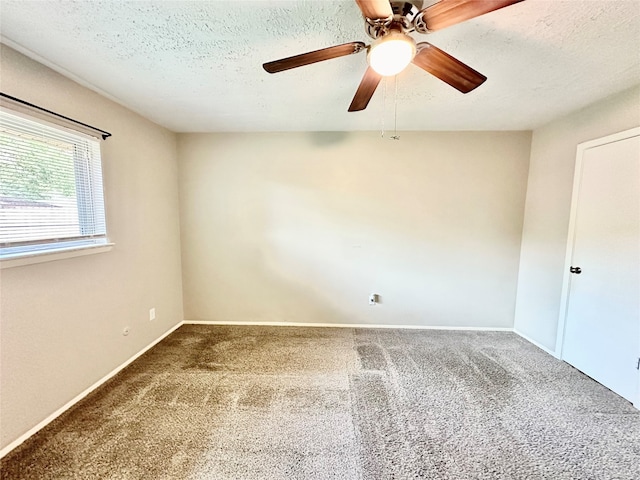 empty room featuring ceiling fan, carpet floors, and a textured ceiling