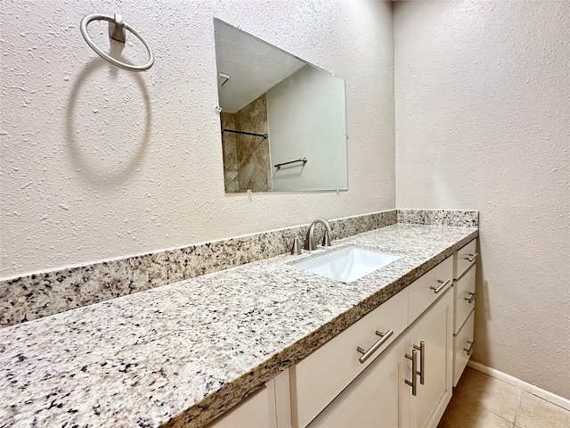 bathroom featuring tile patterned flooring, walk in shower, and vanity