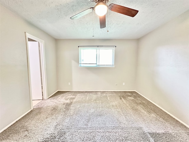 carpeted spare room featuring ceiling fan and a textured ceiling