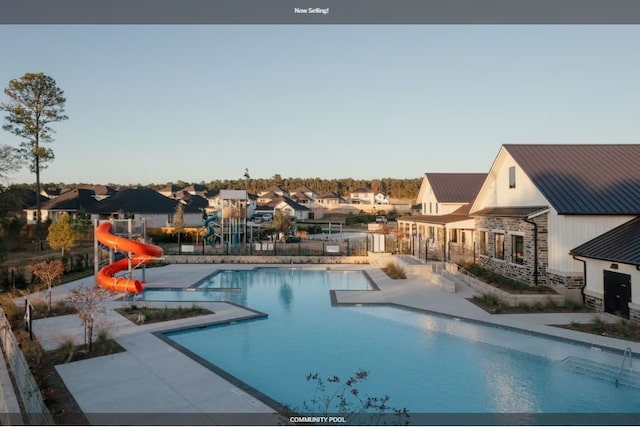 view of pool featuring a water slide and a patio area