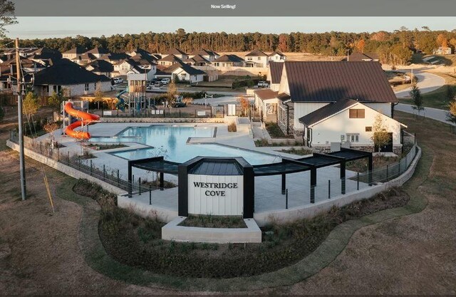 view of swimming pool with a water slide and a patio