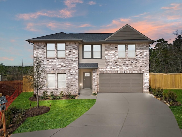 traditional-style house with concrete driveway, an attached garage, fence, a front lawn, and brick siding