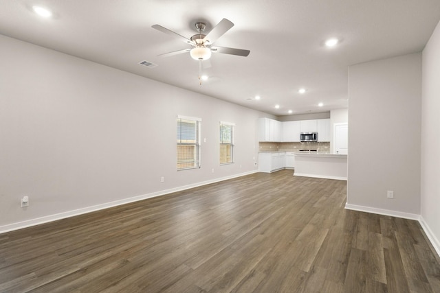 unfurnished living room with dark wood-type flooring and ceiling fan