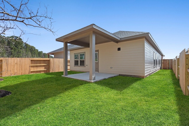 back of house with a yard and a patio