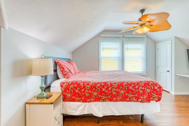 bedroom featuring wood-type flooring, a textured ceiling, vaulted ceiling, and ceiling fan