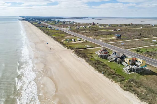 drone / aerial view with a water view and a beach view