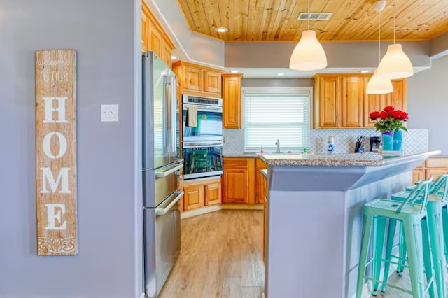 kitchen featuring a breakfast bar area, light hardwood / wood-style flooring, wood ceiling, decorative light fixtures, and stainless steel appliances