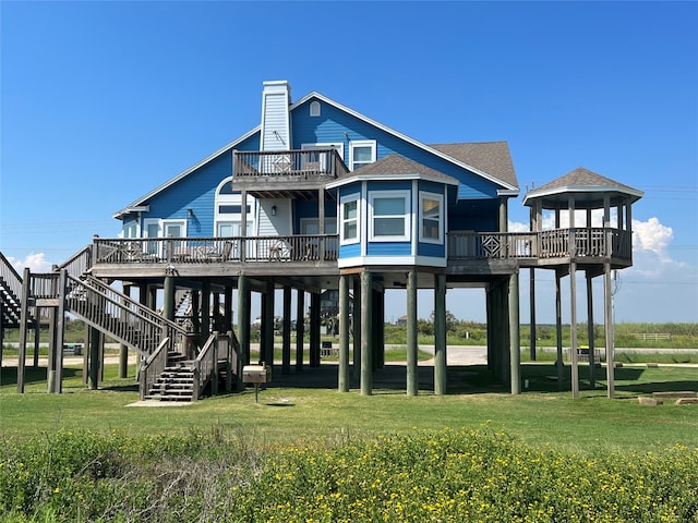 back of house featuring a deck and a lawn