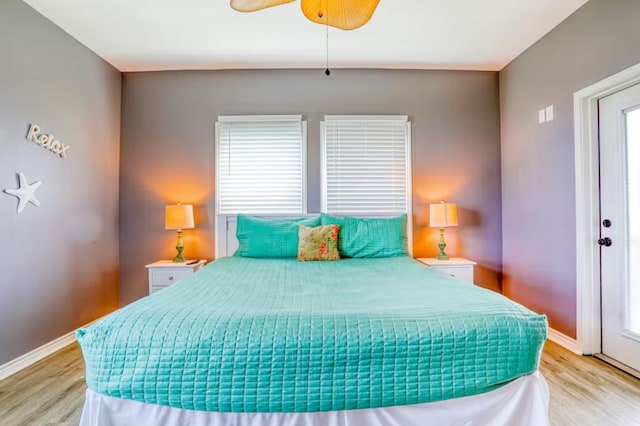 bedroom featuring light hardwood / wood-style floors, multiple windows, and ceiling fan