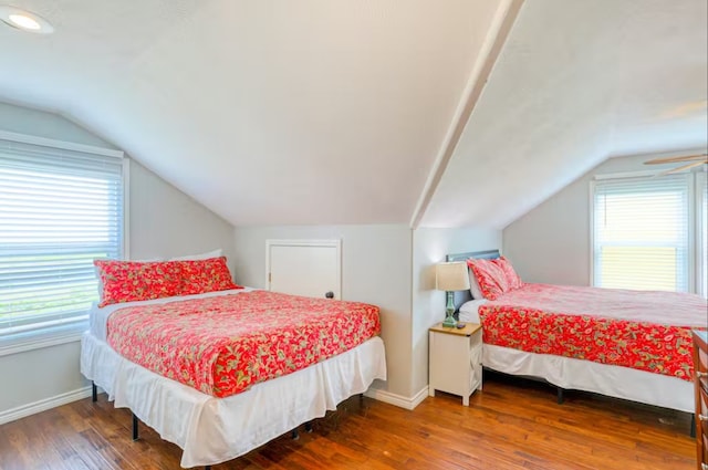 bedroom featuring multiple windows, vaulted ceiling, and dark hardwood / wood-style flooring