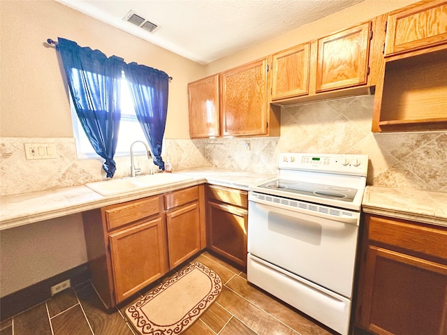 kitchen with white electric range oven, tile countertops, sink, and decorative backsplash