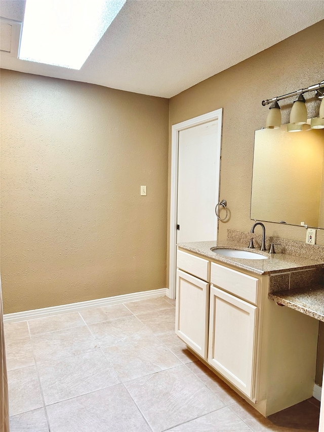 bathroom featuring tile patterned floors, vanity, and a textured ceiling