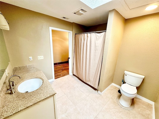 bathroom with toilet, tile patterned flooring, and vanity