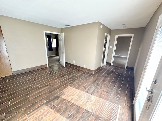 empty room featuring dark hardwood / wood-style flooring and a healthy amount of sunlight