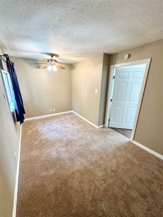 carpeted spare room featuring ceiling fan and a textured ceiling