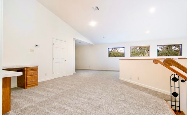 interior space with light carpet and high vaulted ceiling