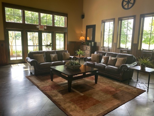 living room featuring a high ceiling and concrete floors