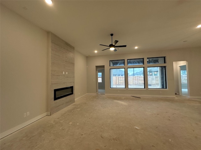 unfurnished living room with a tile fireplace and ceiling fan