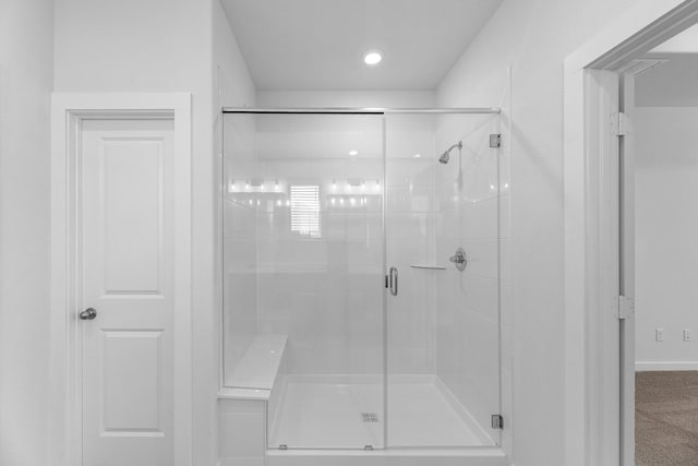 bathroom featuring a shower with shower door