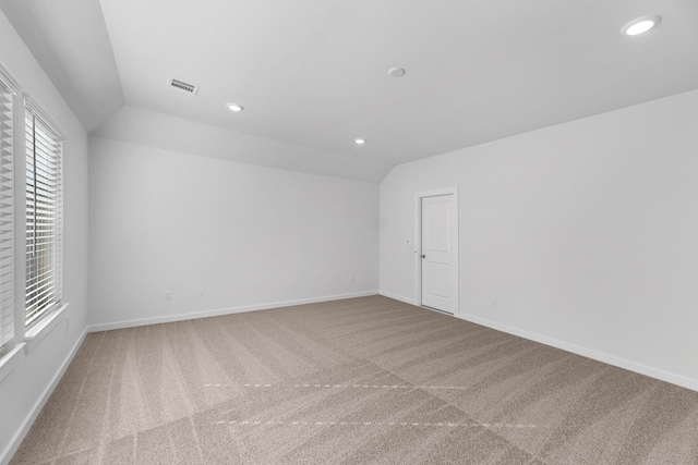 empty room featuring carpet and lofted ceiling