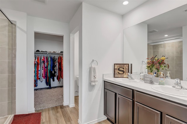 bathroom featuring an enclosed shower, wood-type flooring, vanity, and toilet