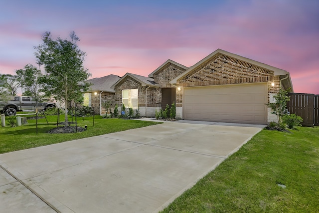 view of front of house with a garage and a yard