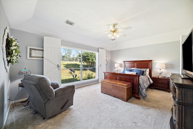 carpeted bedroom with ceiling fan and a tray ceiling